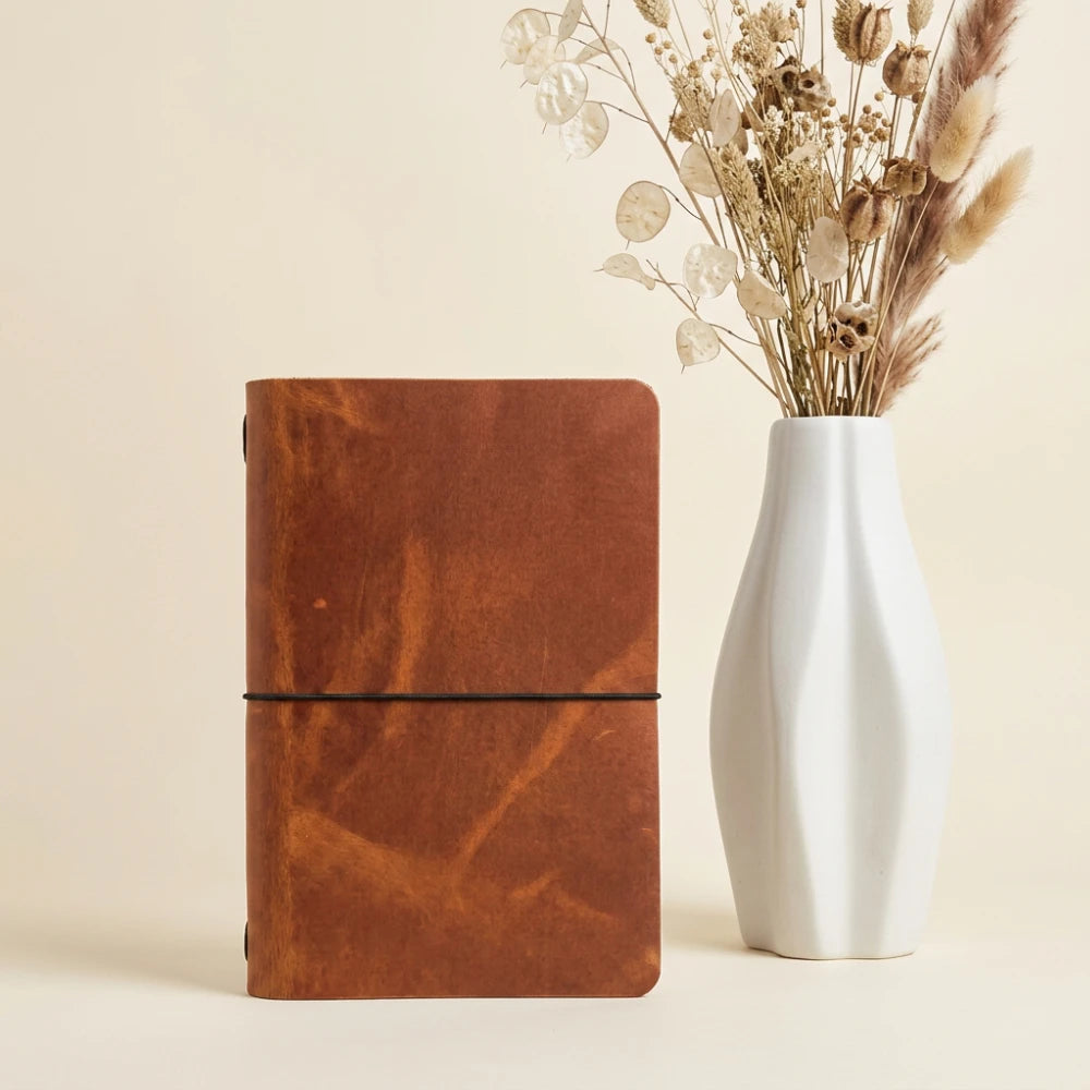 Natural leather cover with timeless design, holding a plain notebook securely inside.