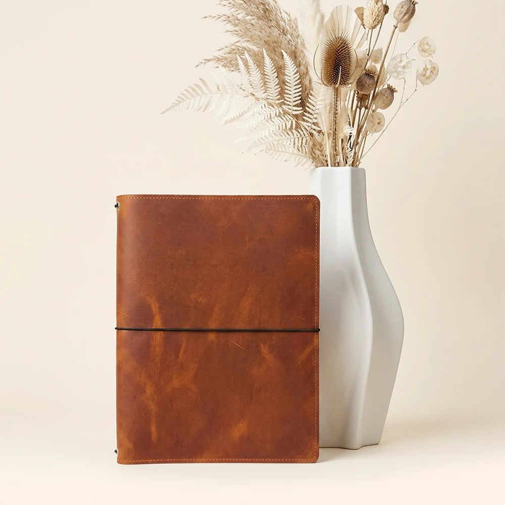 Natural leather journal case with three internal elastics for holding multiple inserts.