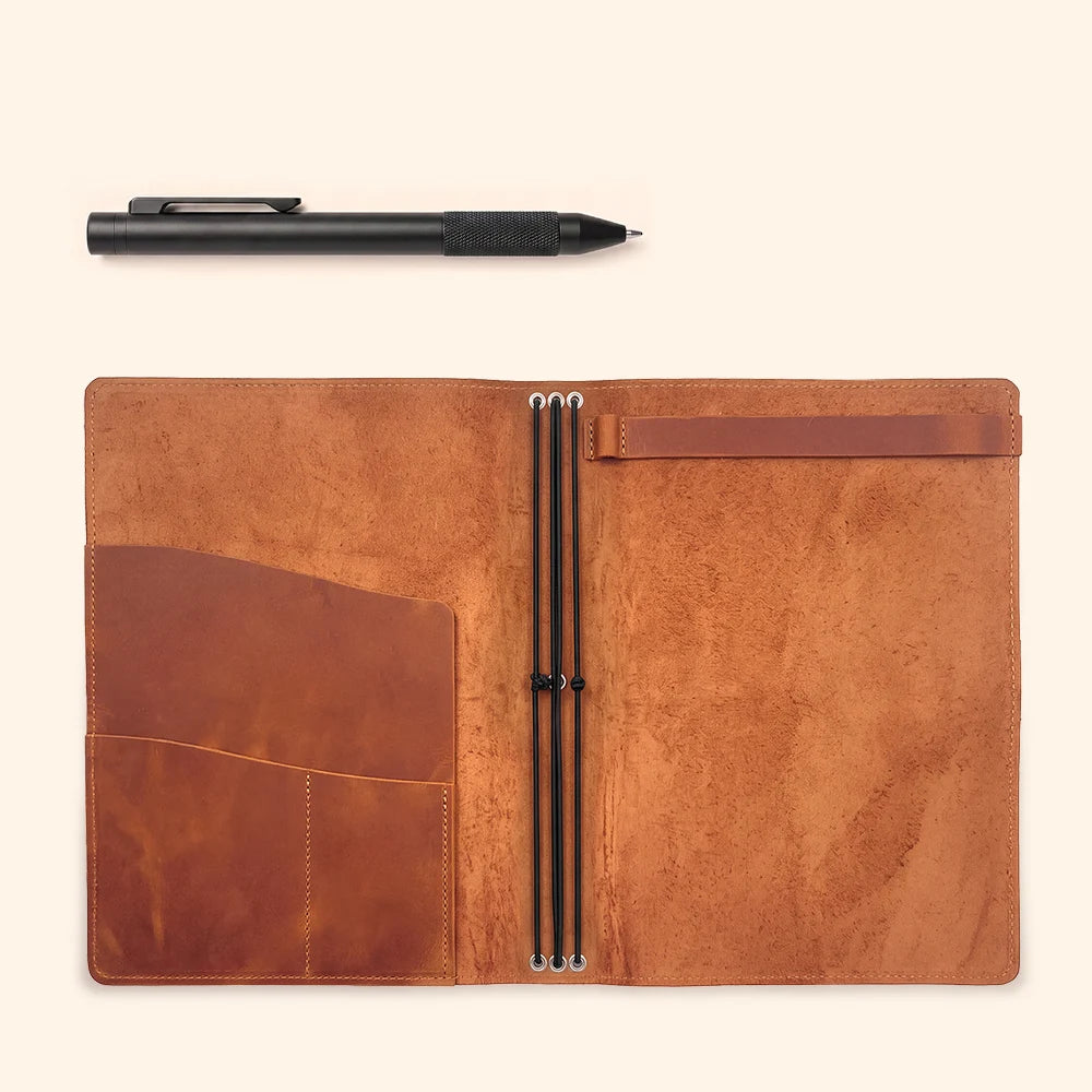 Open leather sketchbook case displaying its organized interior and elastic retention system.