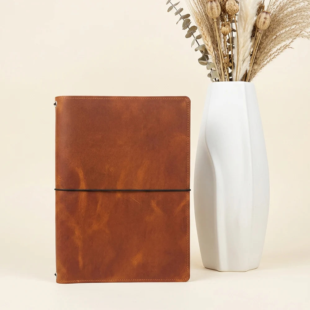 Handmade notebook cover with natural leather lining, storage pockets, and flexible loops.