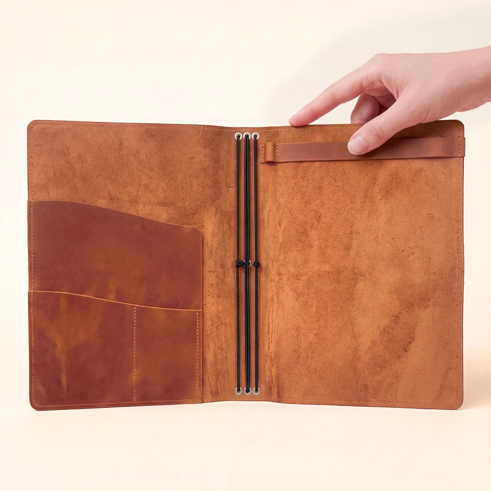 Natural leather notebook portfolio with flexible loops for securely carrying multiple inserts.