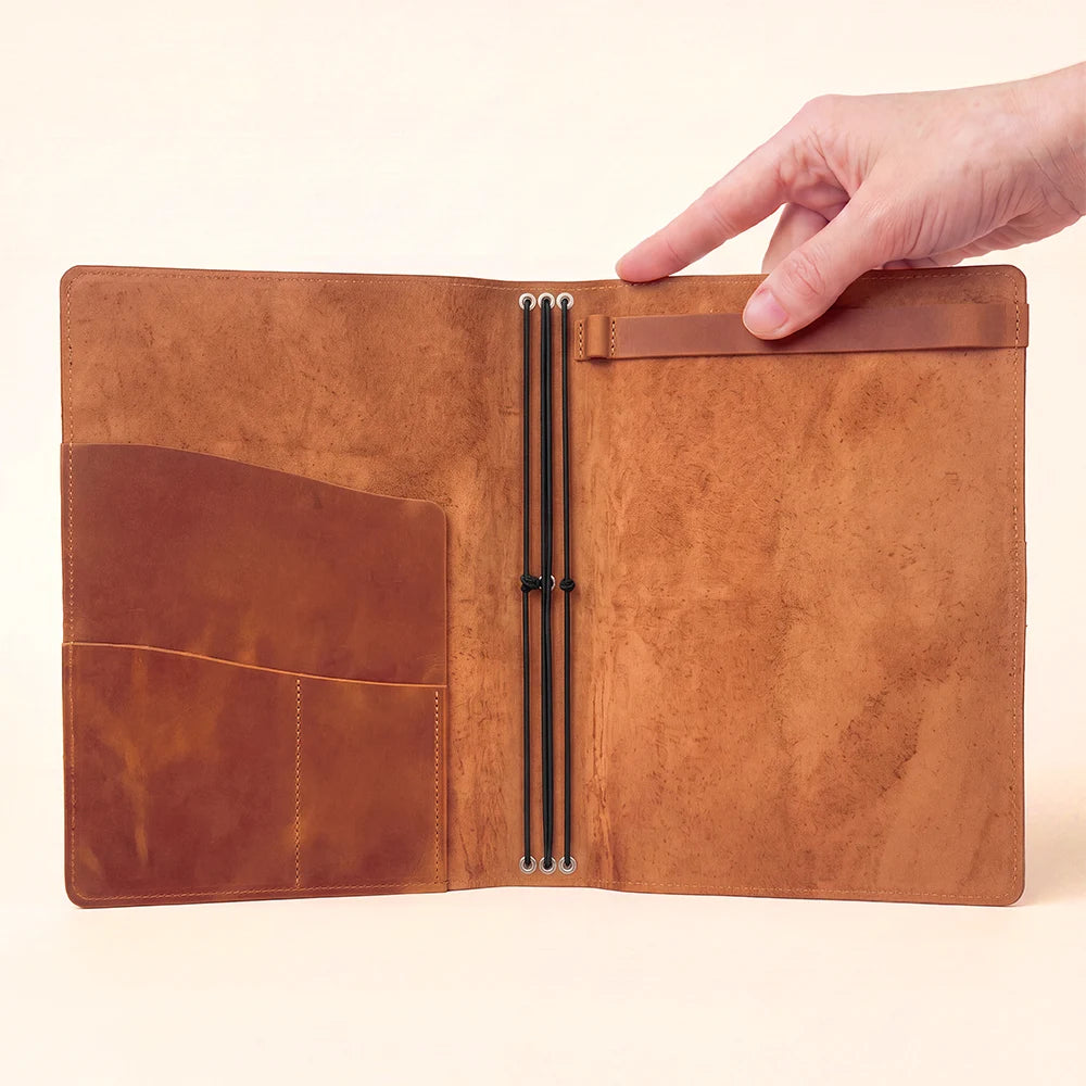 Natural leather journal cover designed with three elastic bands and interior storage.