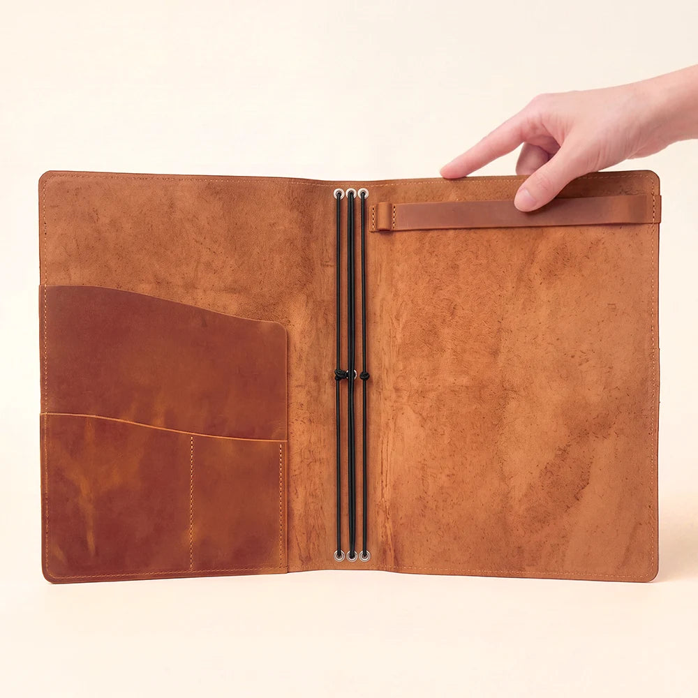 Leather notebook holder opened to reveal a clean and functional storage arrangement.