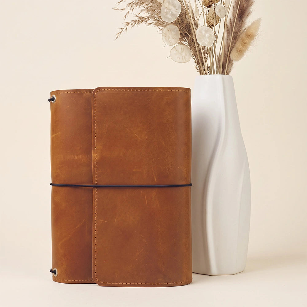 Leather notebook wallet featuring interior card slots and secure pen carrying loop.