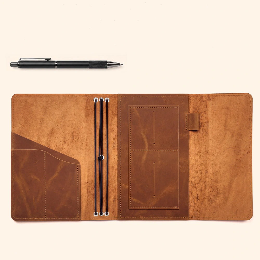 Leather notebook cover offering organized storage space and integrated leather pen holder feature.