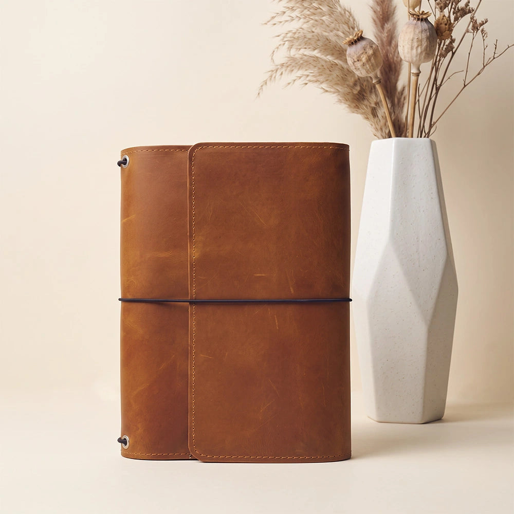 Full grain leather writing organizer with functional compartments and stitched pen carrying loop.