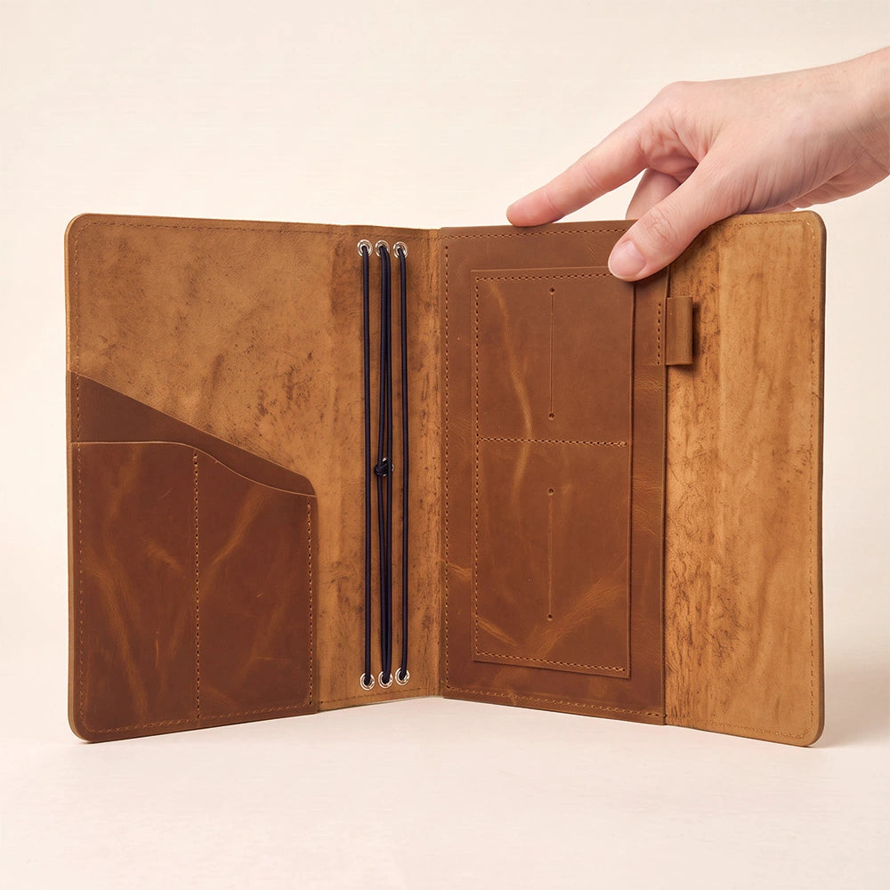 Elegant leather journal cover with inner compartments and durable leather pen holder included.