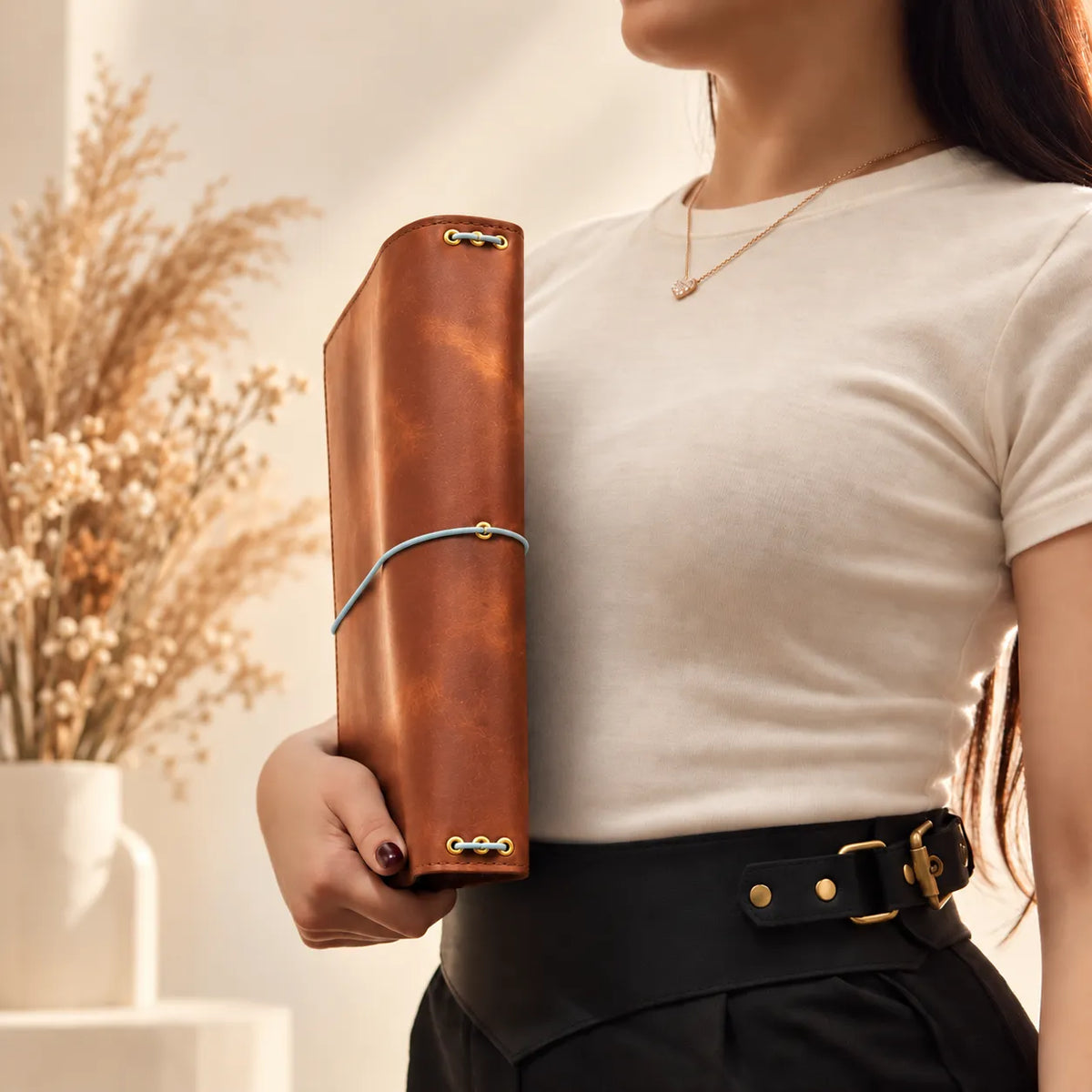 Young woman displaying a genuine leather journal cover with a classic design and natural texture.