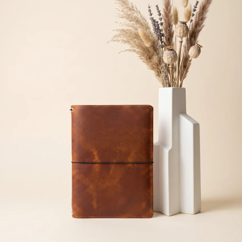 Leather notebook cover with a triple elastic interior for flexible refill changes.