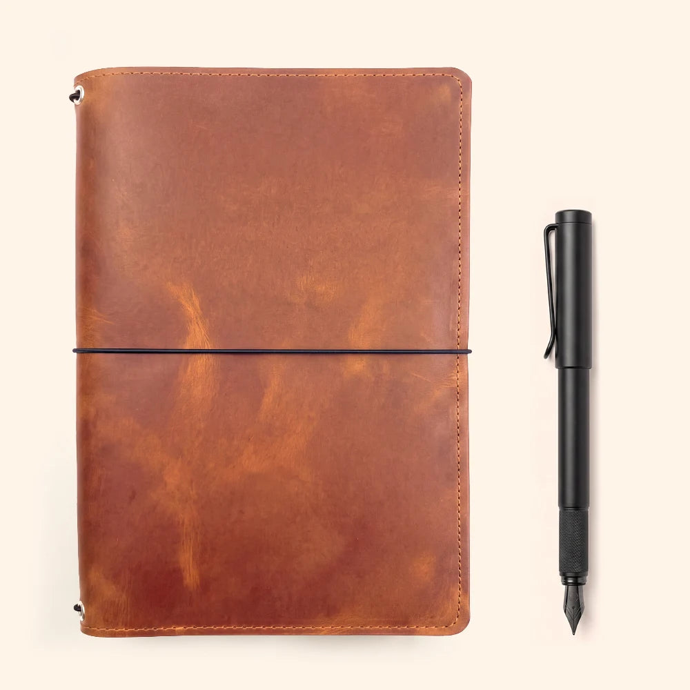 Natural leather journal sleeve supporting three interchangeable paper booklets.