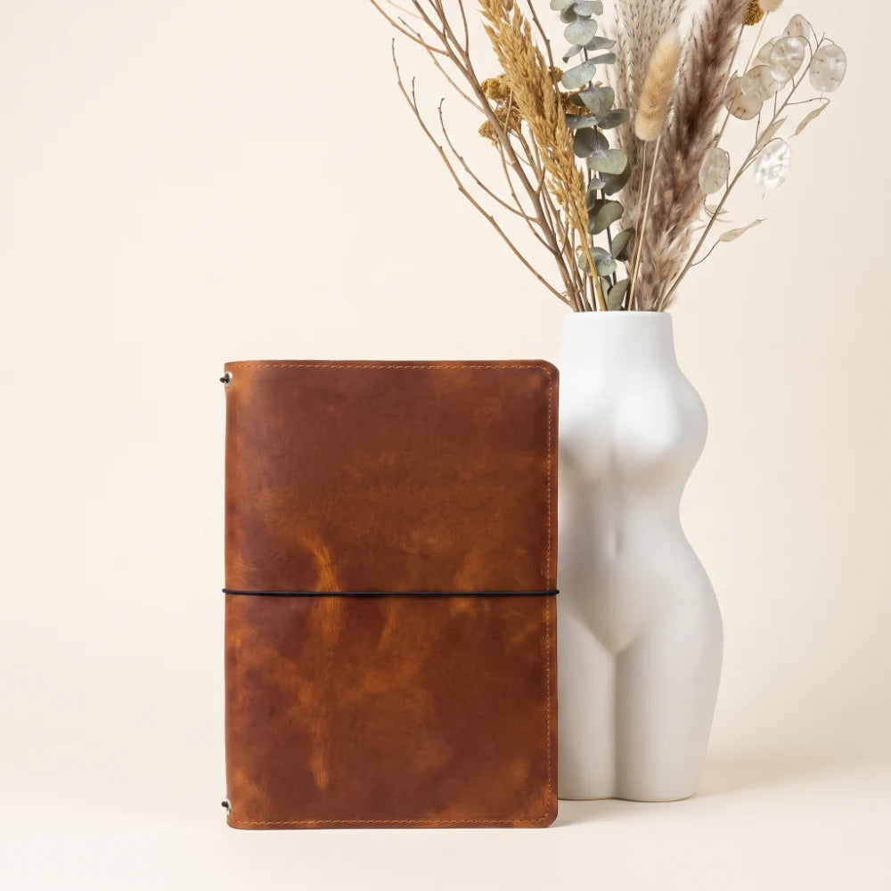 Genuine leather travel notebook cover with three interior elastic bands for organization.
