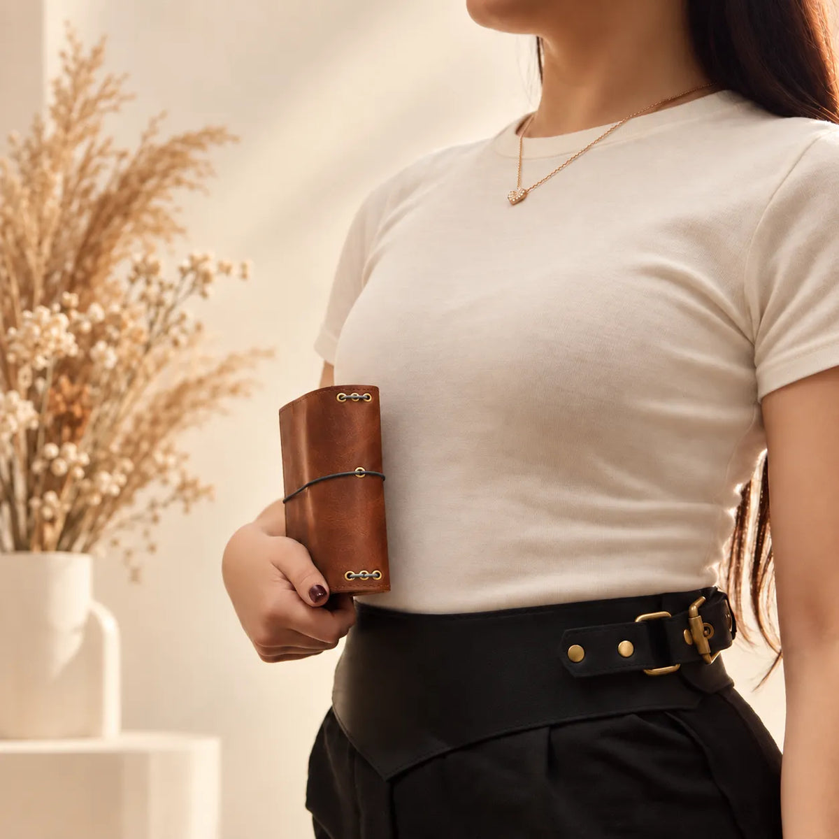 Young woman presenting a handmade leather journal cover with visible grain and durable construction