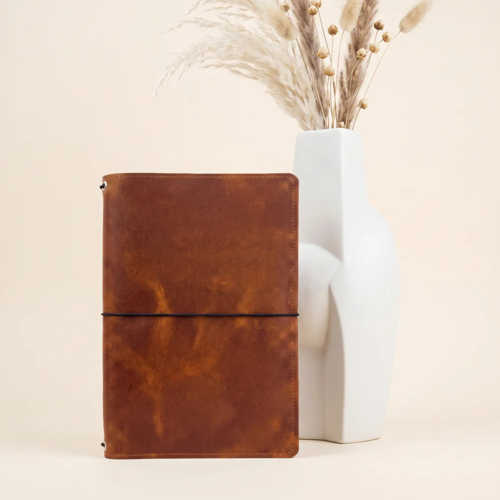Handmade leather planner holder featuring three flexible elastic loops inside.