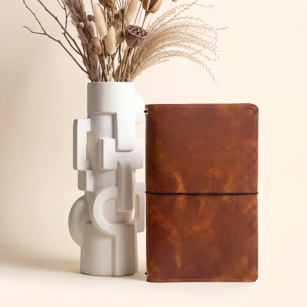 Versatile leather journal cover with space for three independently replaceable inserts.