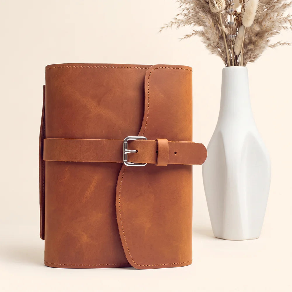 Genuine leather journal wrap with organized storage areas, pen loop, attached bookmark, and comfortable carrying grip.