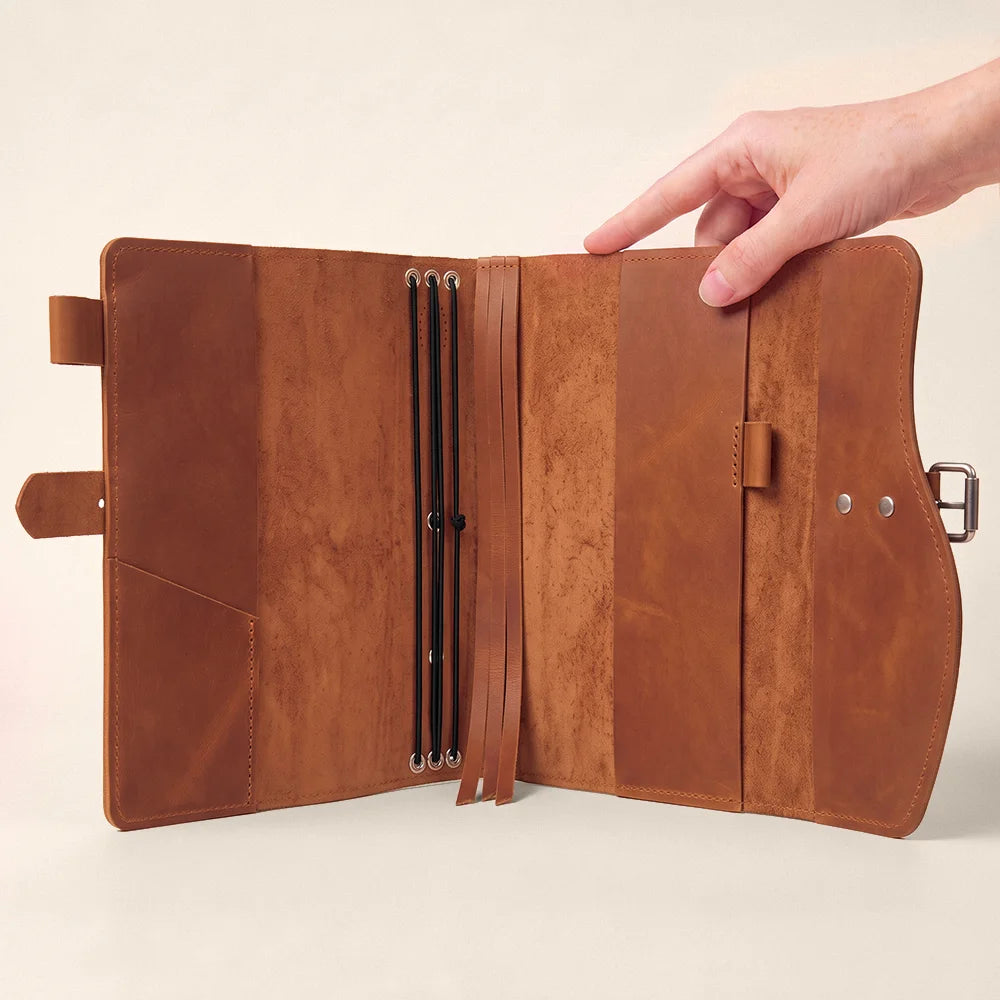 Natural leather writing carrier with organized pockets, dedicated pen strap, built-in page marker, and sturdy carry handle.