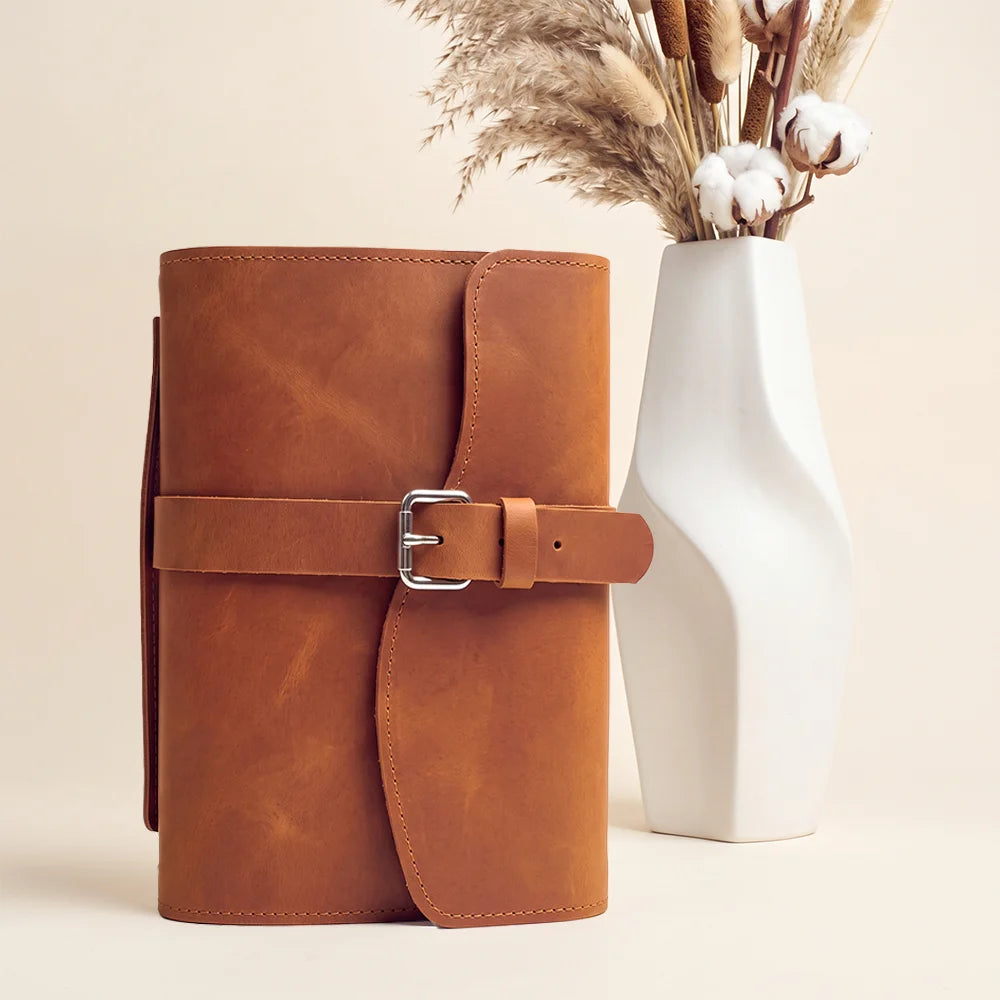 Leather writing organizer with multiple pockets, elastic pen loop, attached bookmark, and convenient carry grip.