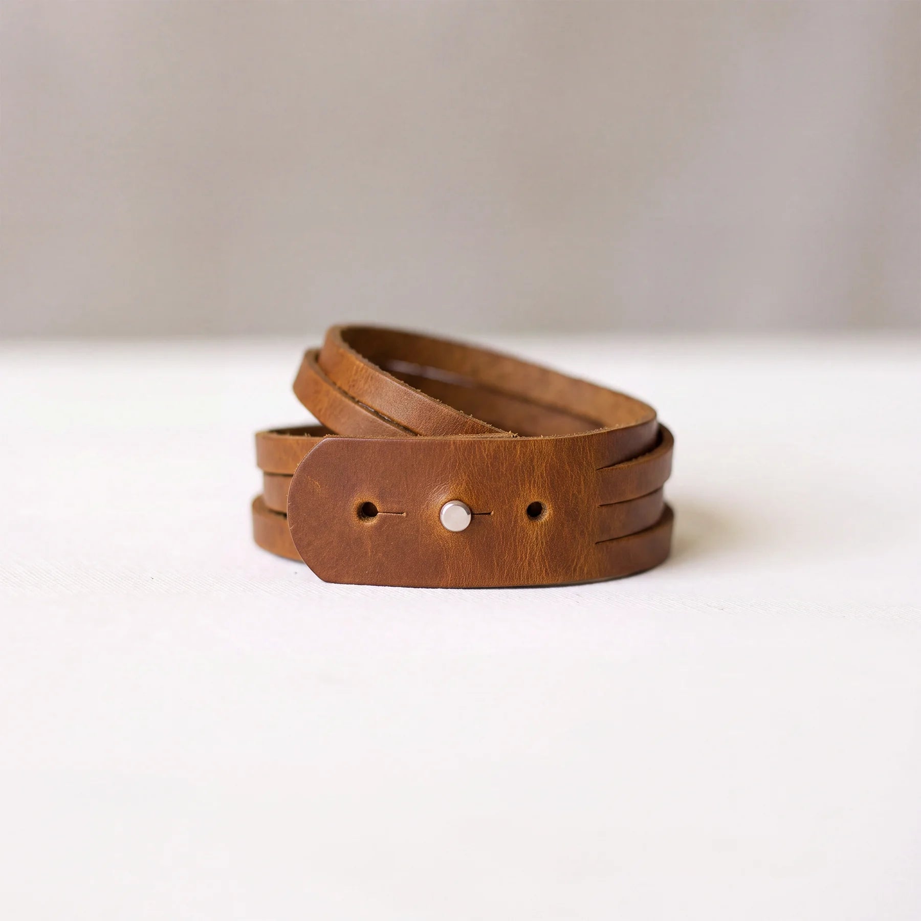 Genuine leather cuff bracelet with polished snap closure and durable handcrafted construction.