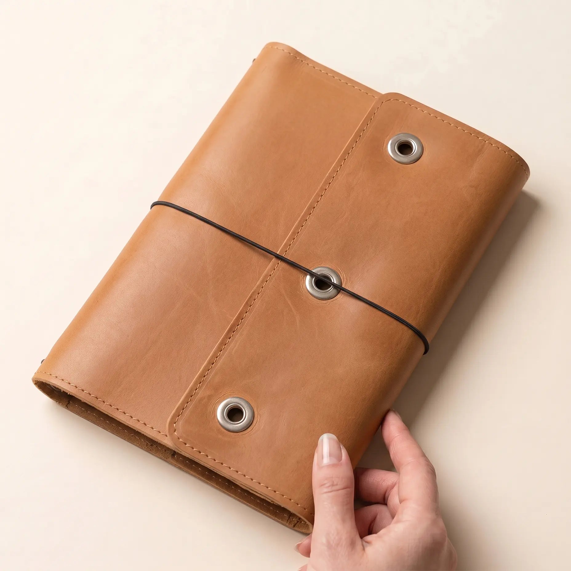 Handmade journal cover with three elastic bands and compartments.