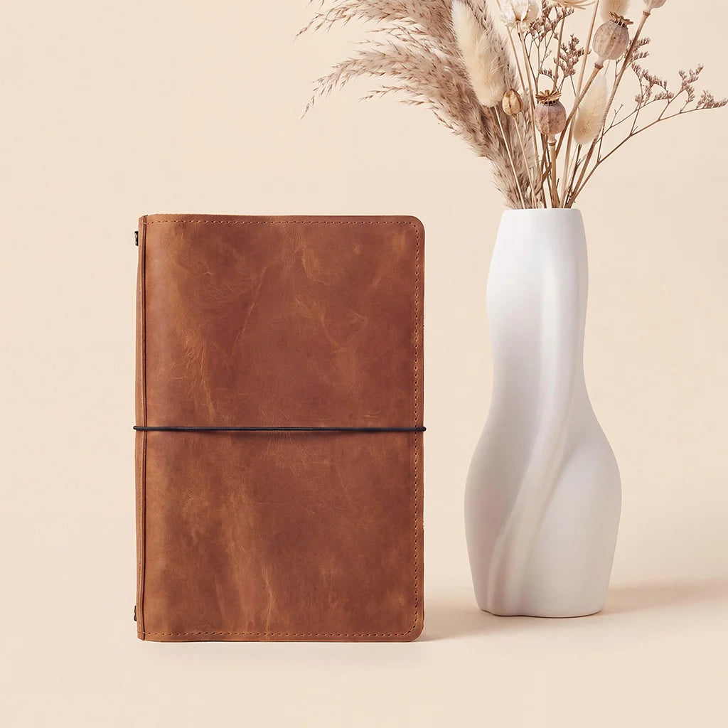 Genuine leather notebook cover providing organized storage and flexible refillable notebook system.