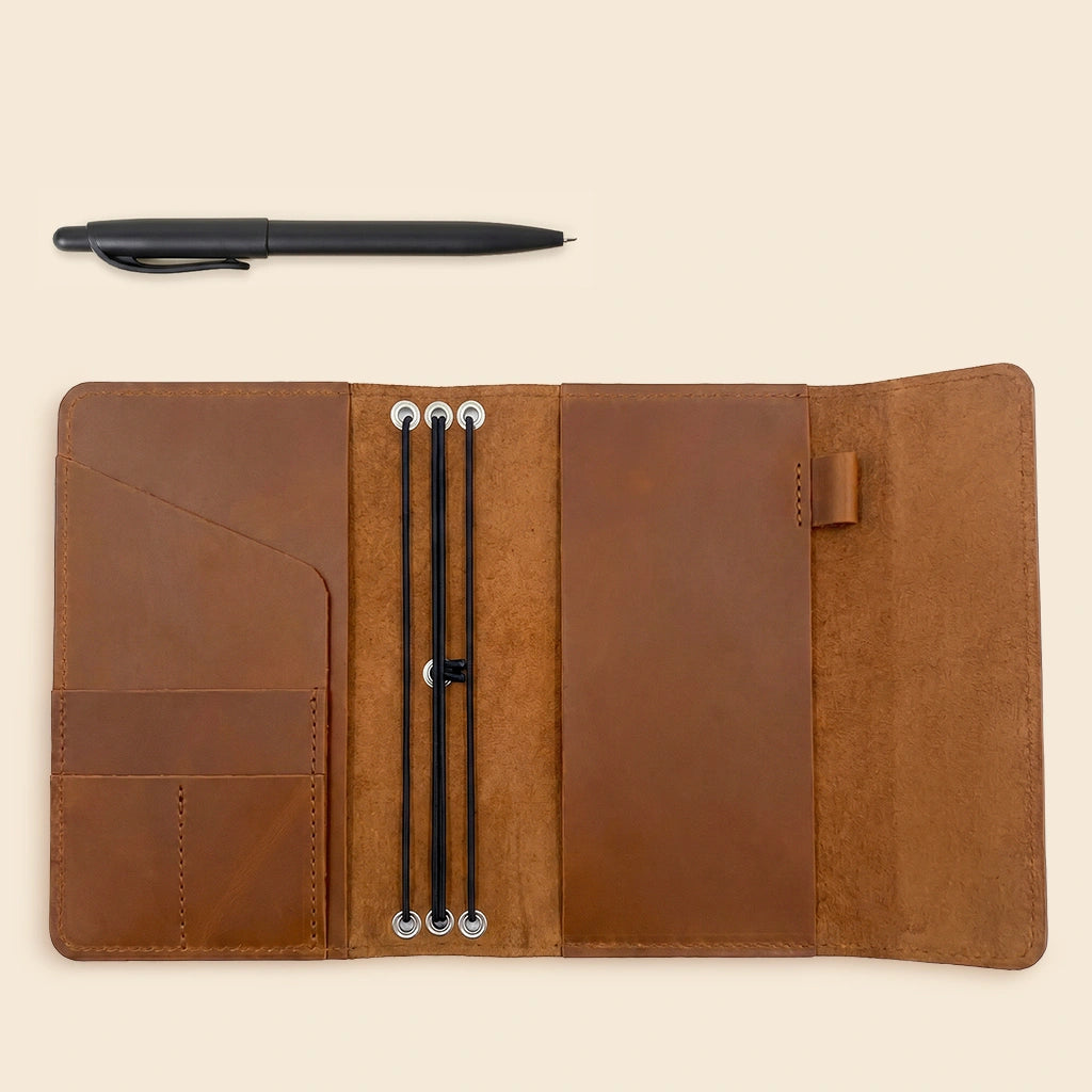 Leather planner cover with handcrafted construction, card pockets, and convenient pen holder.