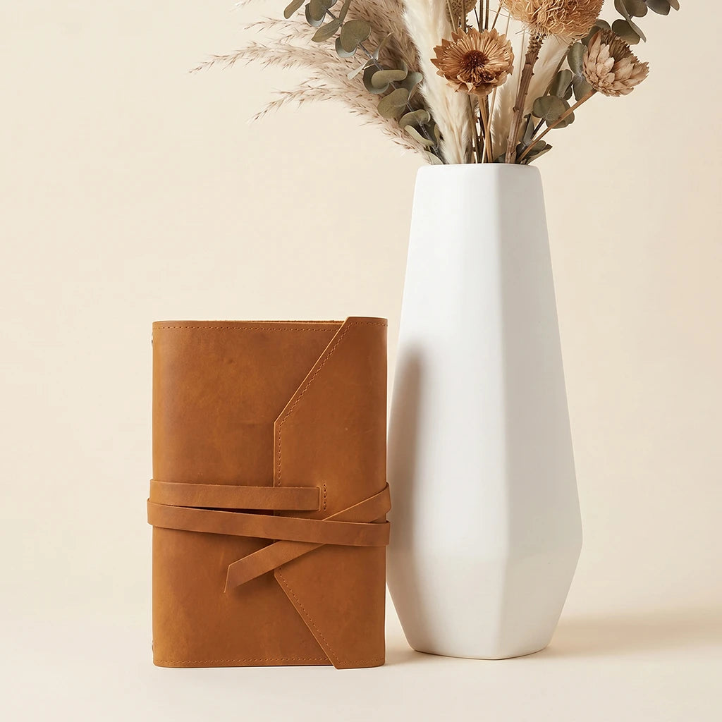 Handmade leather notebook wrap with organized pen loop and secure closure.