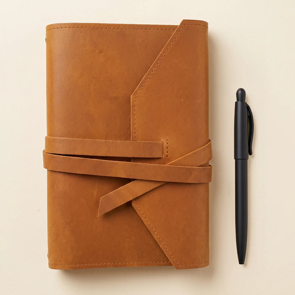 Premium notebook sleeve in leather with pen loop and elastic straps.