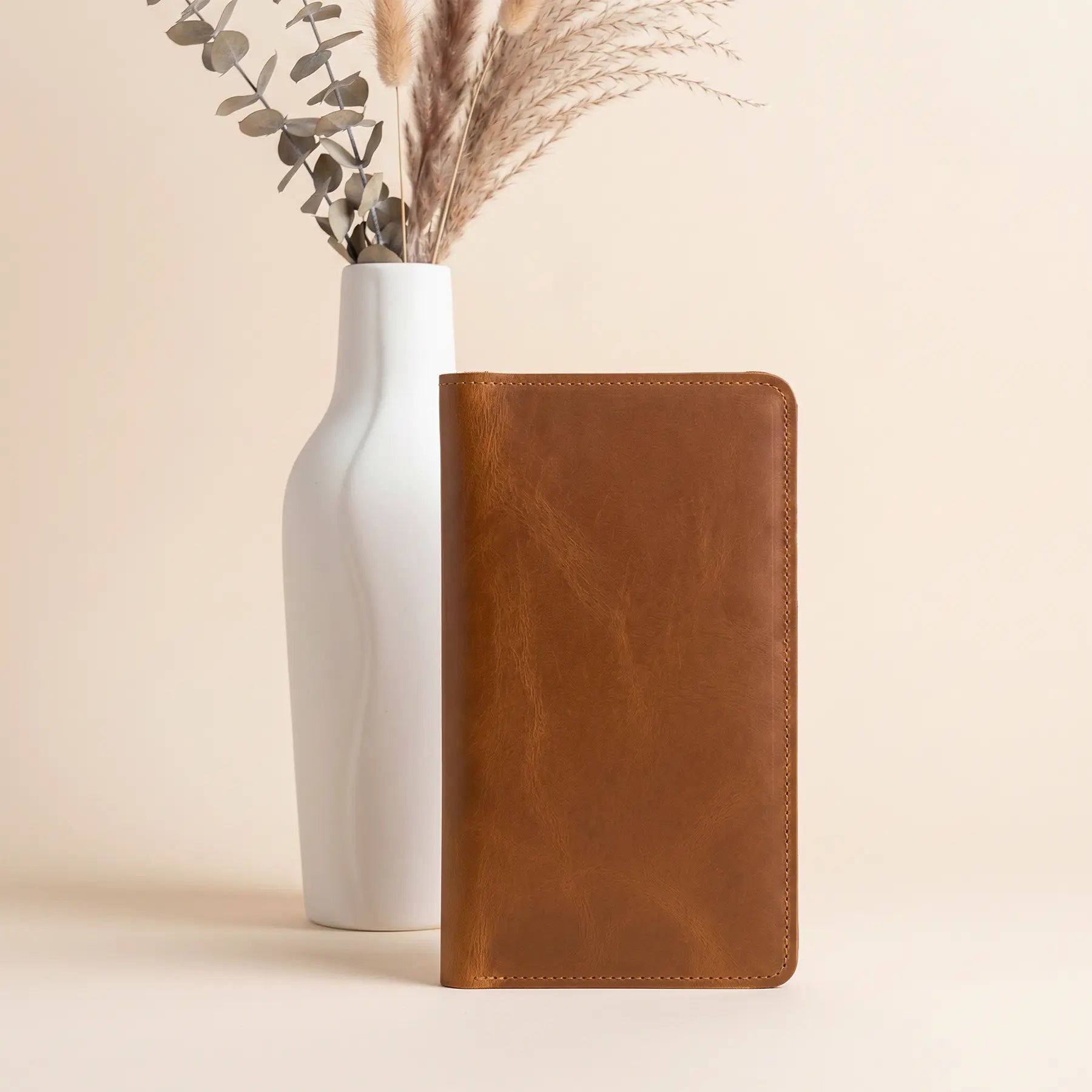 Premium leather long wallet featuring secure snap buttons, credit card slots, and zippered interior pocket.