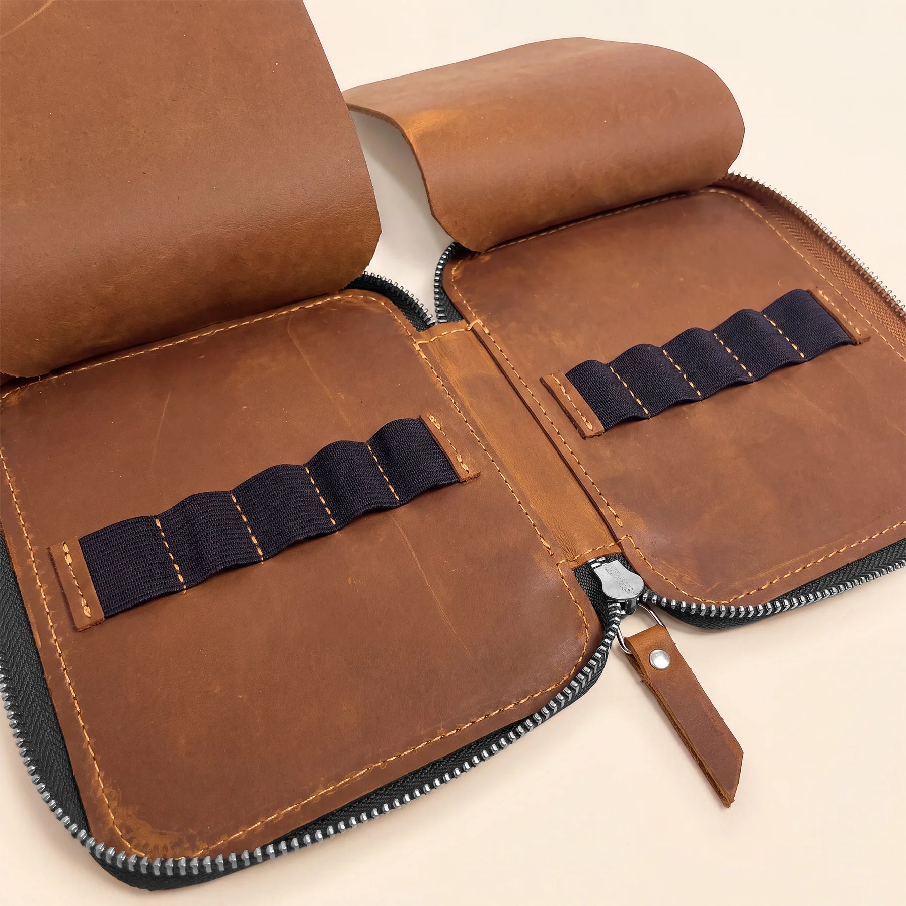 Handmade leather stationery organizer with zipper for everyday pen and pencil storage.
