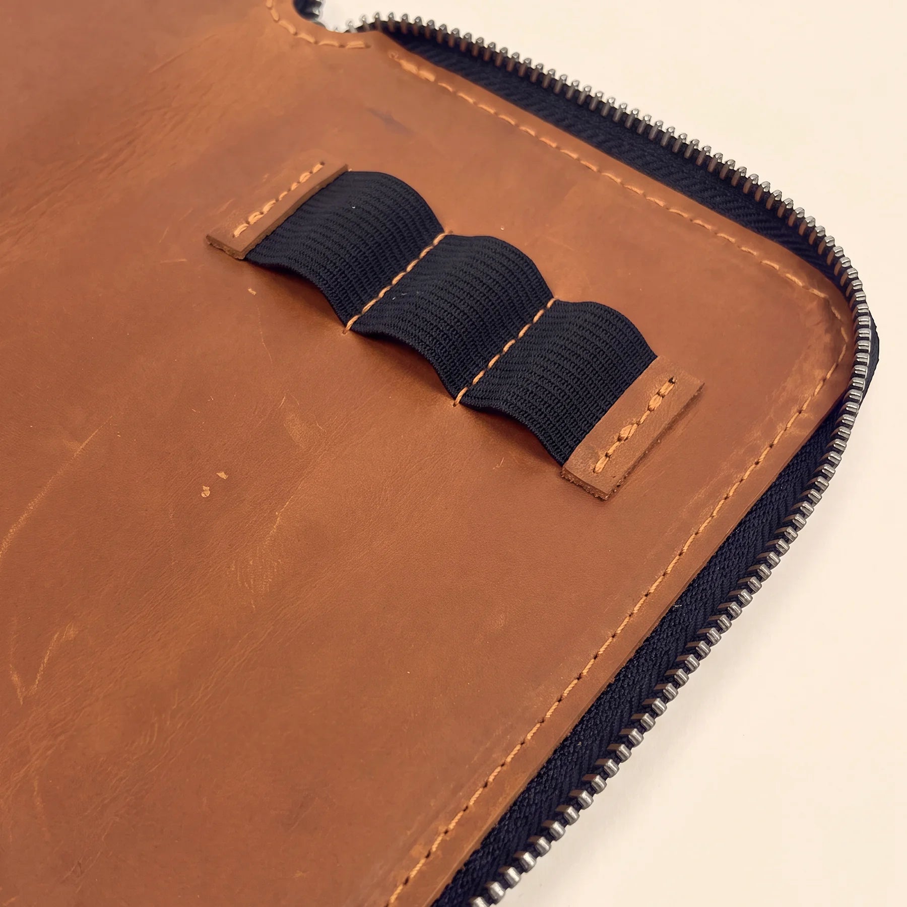 Leather pen organizer pouch with zipper for professional workspace and travel convenience.