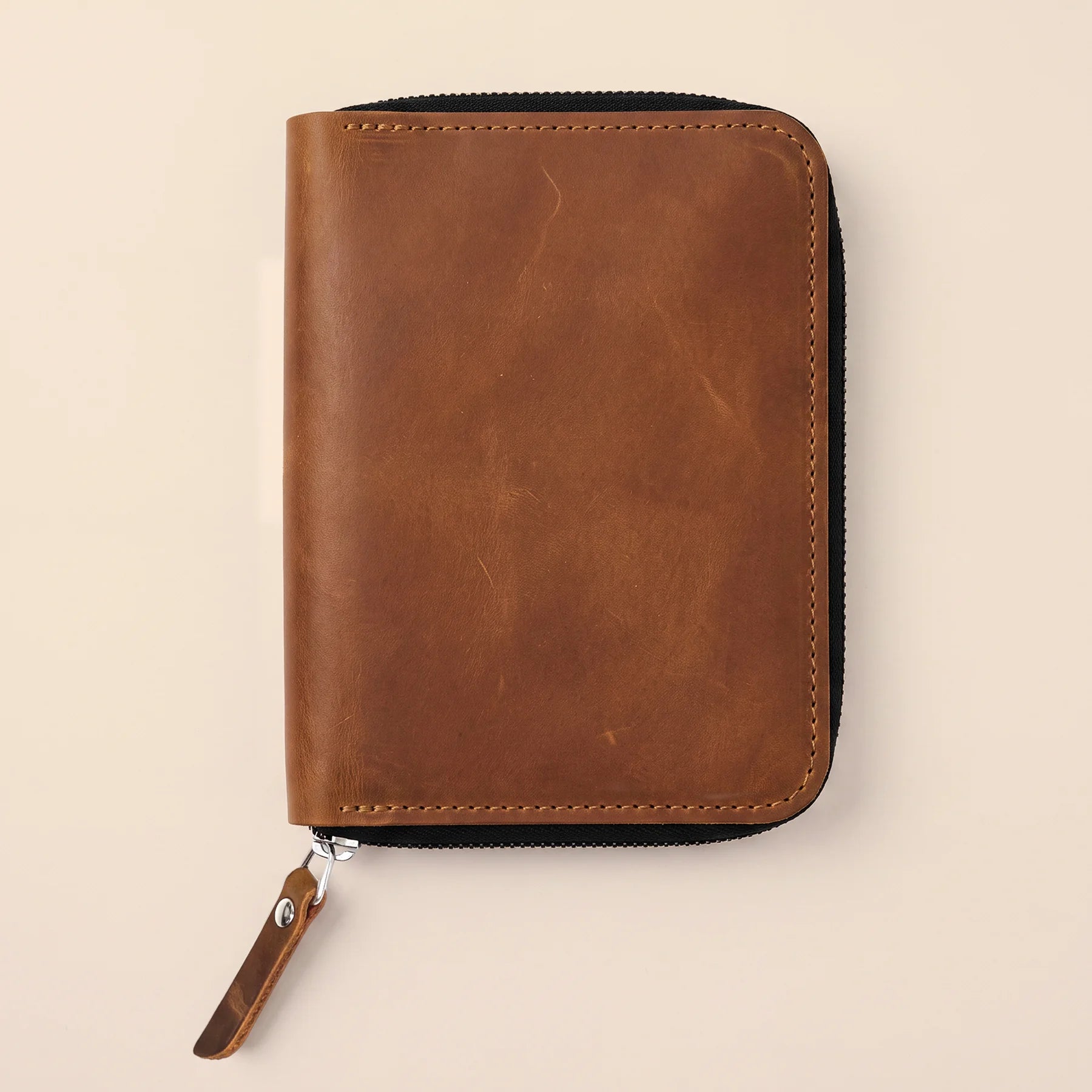 Leather office accessory case with zipper for neatly storing pens and pencils.