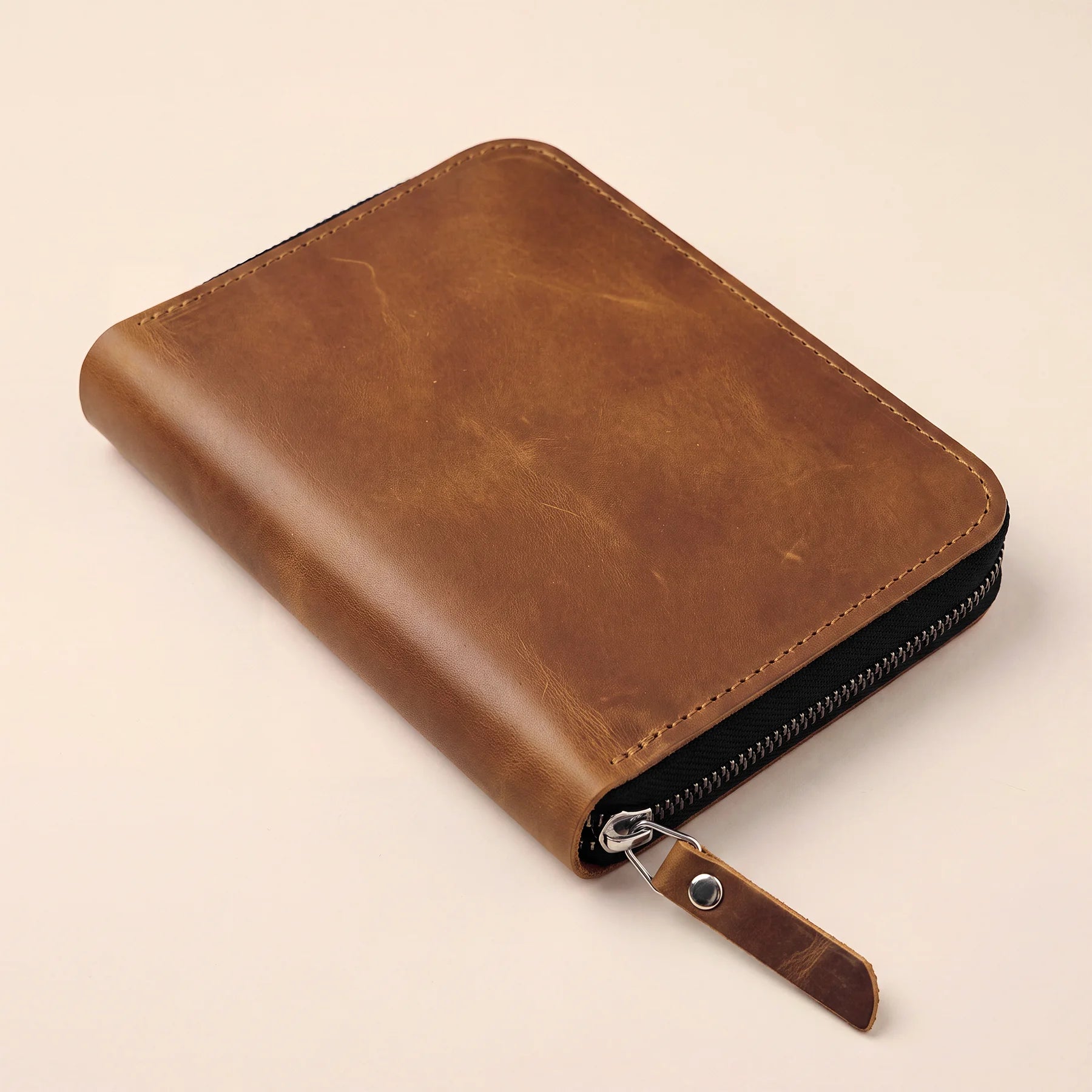 Handcrafted leather supply pouch with zipper for organizing everyday writing accessories.