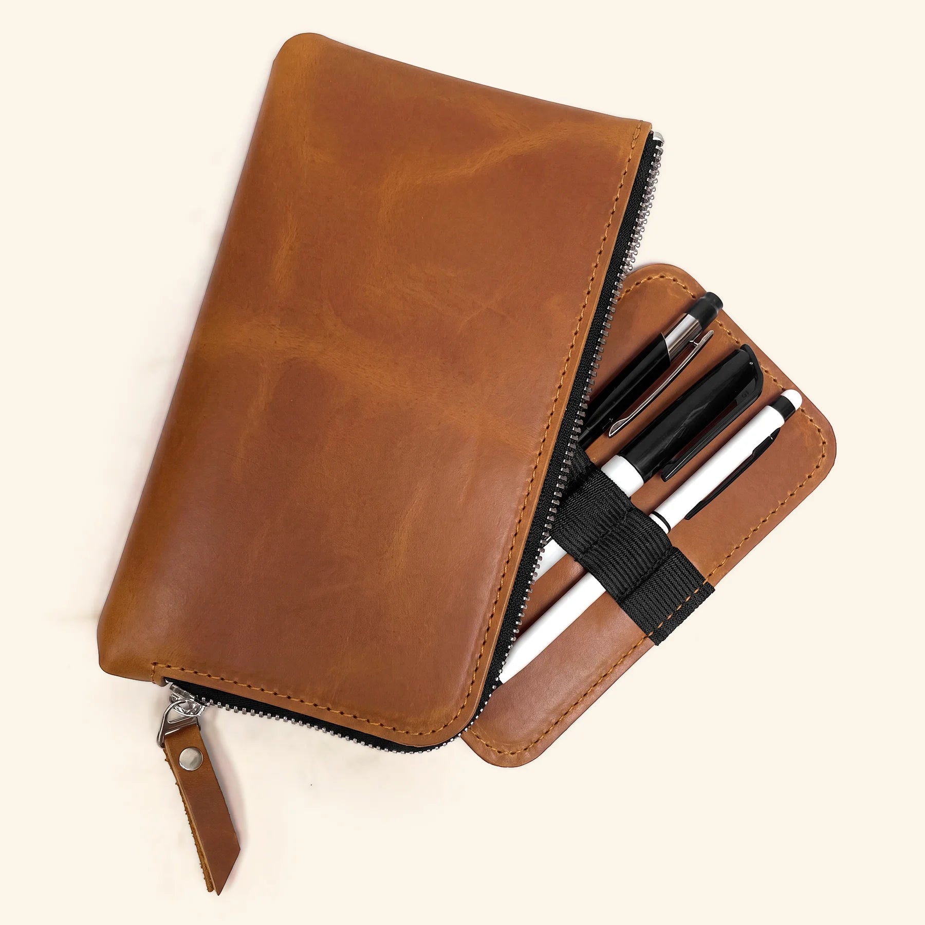 Handmade leather pen accessory holder with zipper and spacious storage compartment.