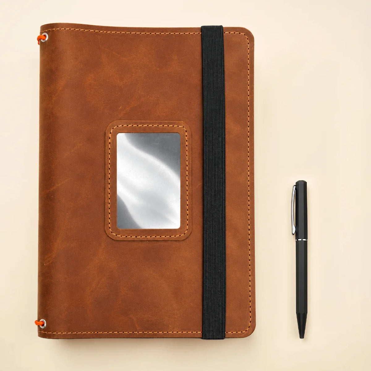 Natural leather journal cover with three elastic notebook holders and functional storage compartments.