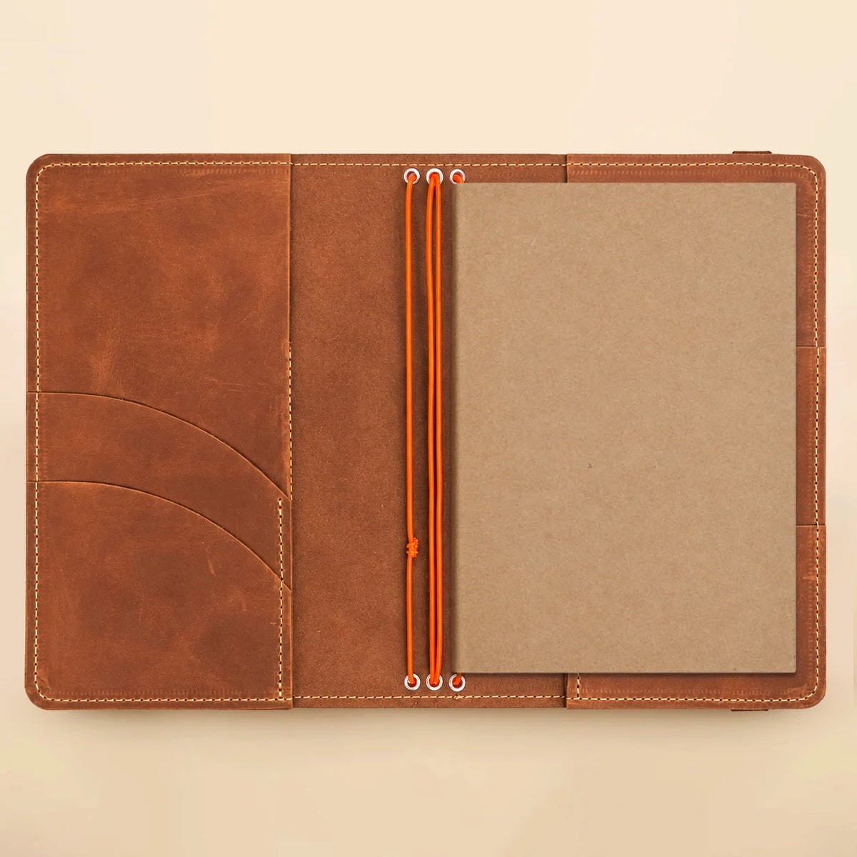 Handmade leather notebook featuring three elastic cords, interior pockets, and a clear photograph display window.