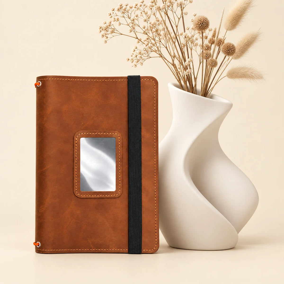 Leather notebook cover made from natural leather with three elastic bands and pockets.