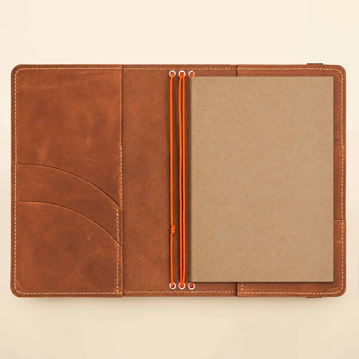Handmade leather journal organizer featuring three flexible straps and convenient built-in pockets.