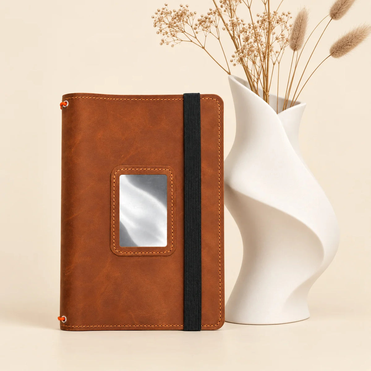 Genuine leather notebook cover showing three elastic holders and neatly positioned inner pockets.