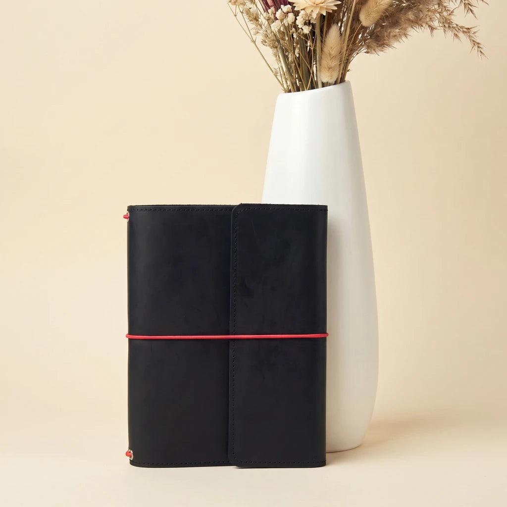 Leather notebook carrier with elastic fastening, inner sleeves, and pen loop detail