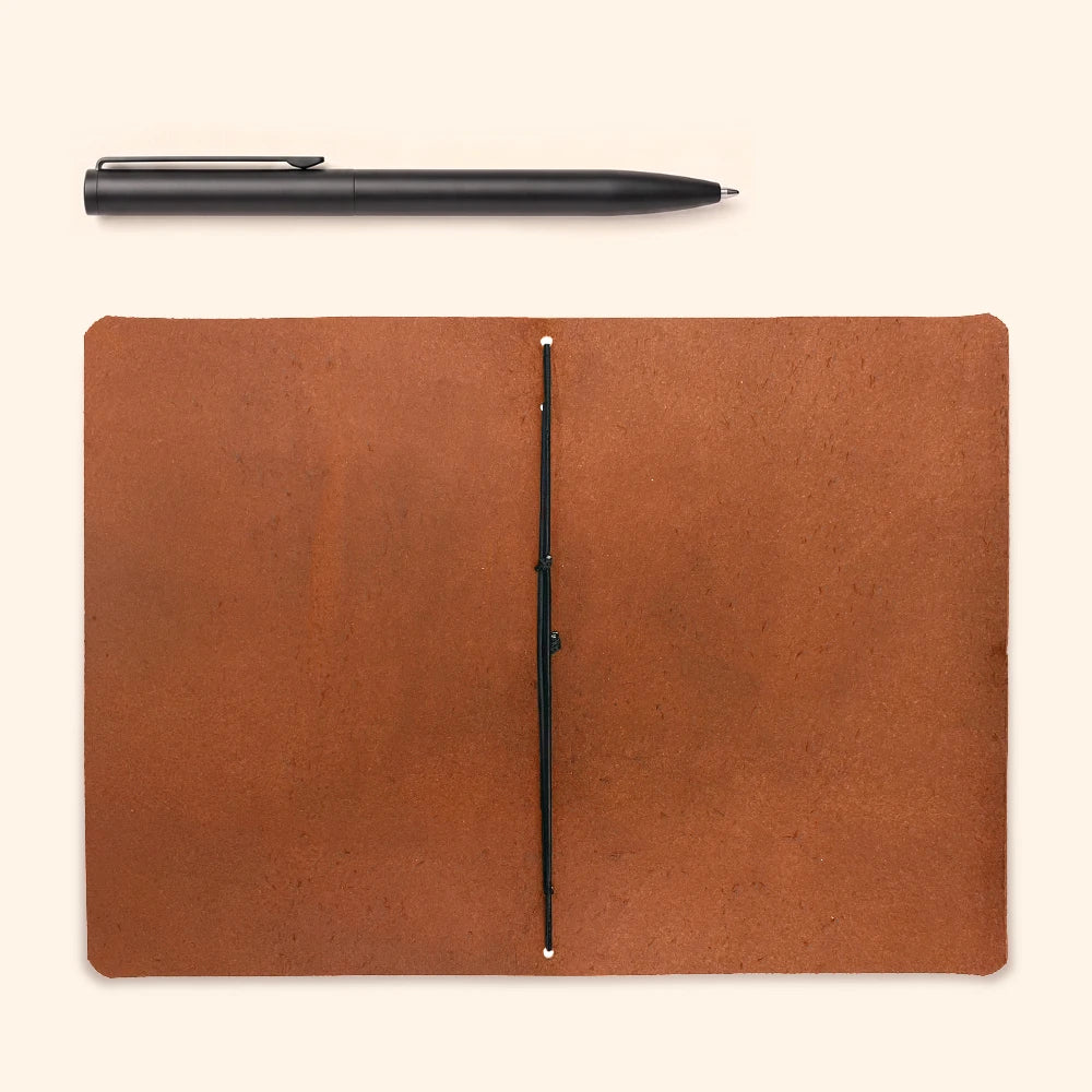 Handcrafted natural leather cover with simple notebook insert and elastic holder inside.