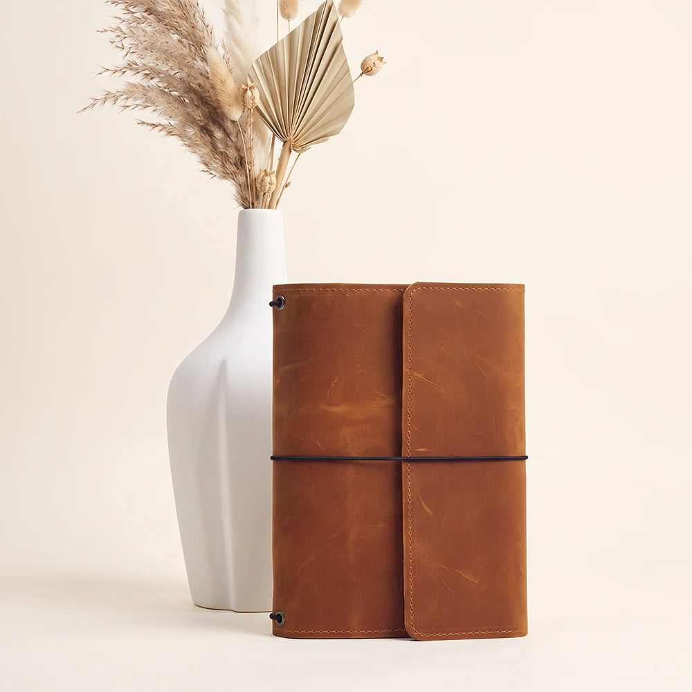 Premium leather notebook holder with refillable journal system and organized inside storage layout.