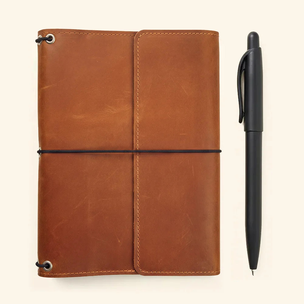 Genuine leather notebook cover with refillable elastic system and organized interior pocket design.