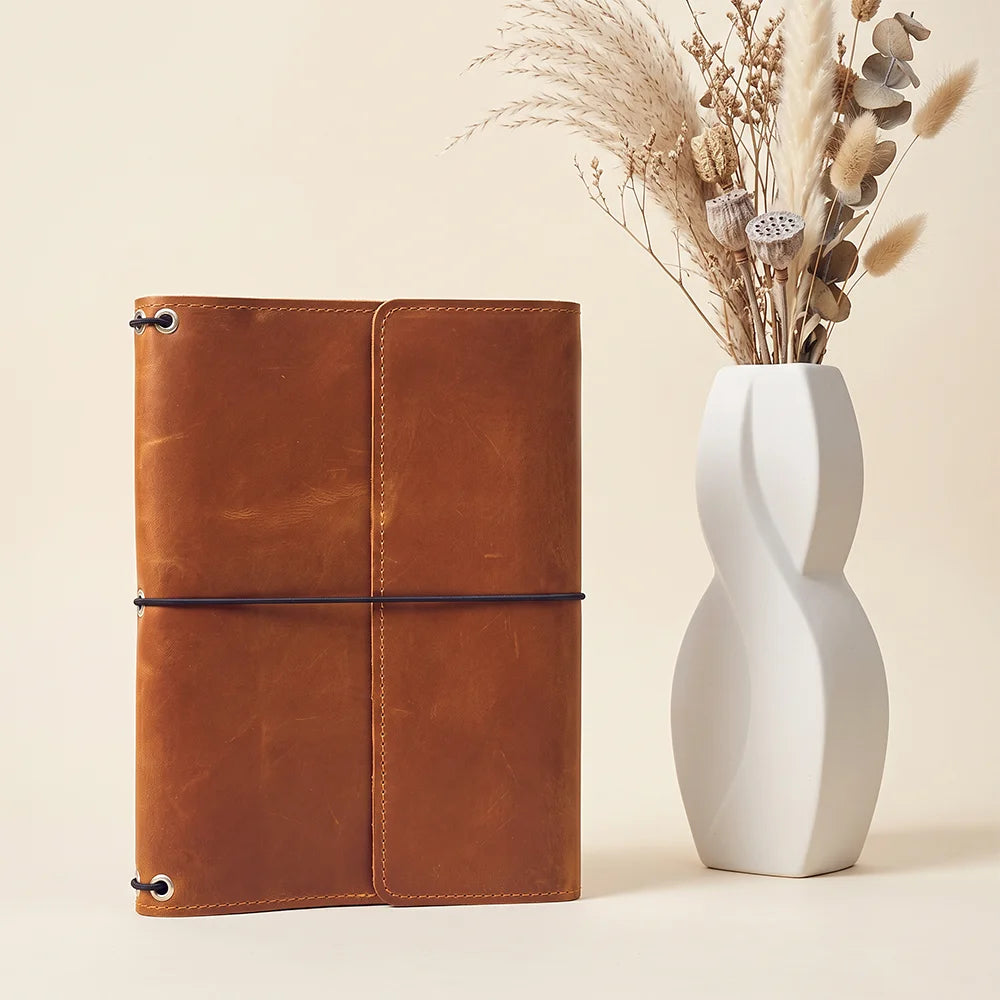 Stylish leather notebook case offering refillable functionality and organized storage for everyday essentials.