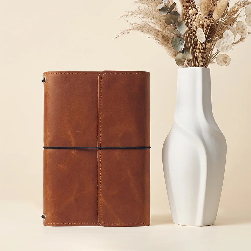 Authentic leather journal organizer featuring multiple stitched pockets and a secure elastic pen holder.