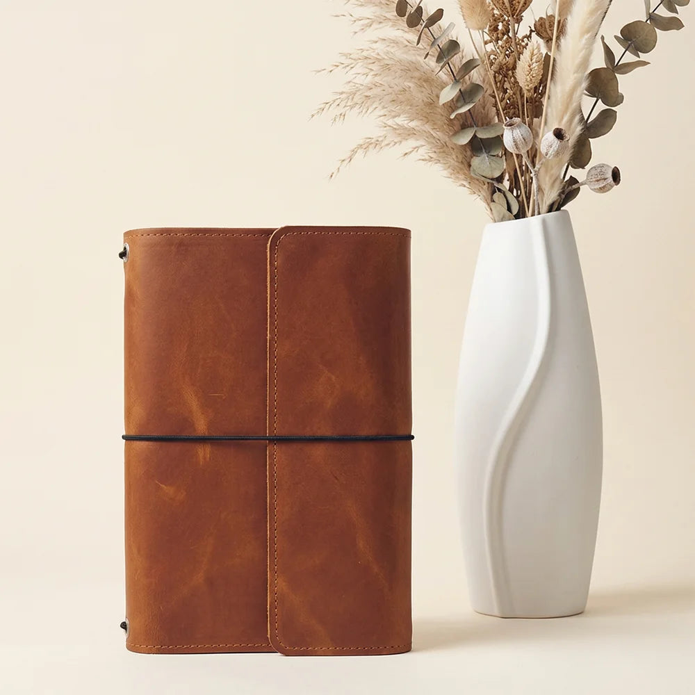 Genuine leather journal cover showing functional interior compartments and a built-in pen holder