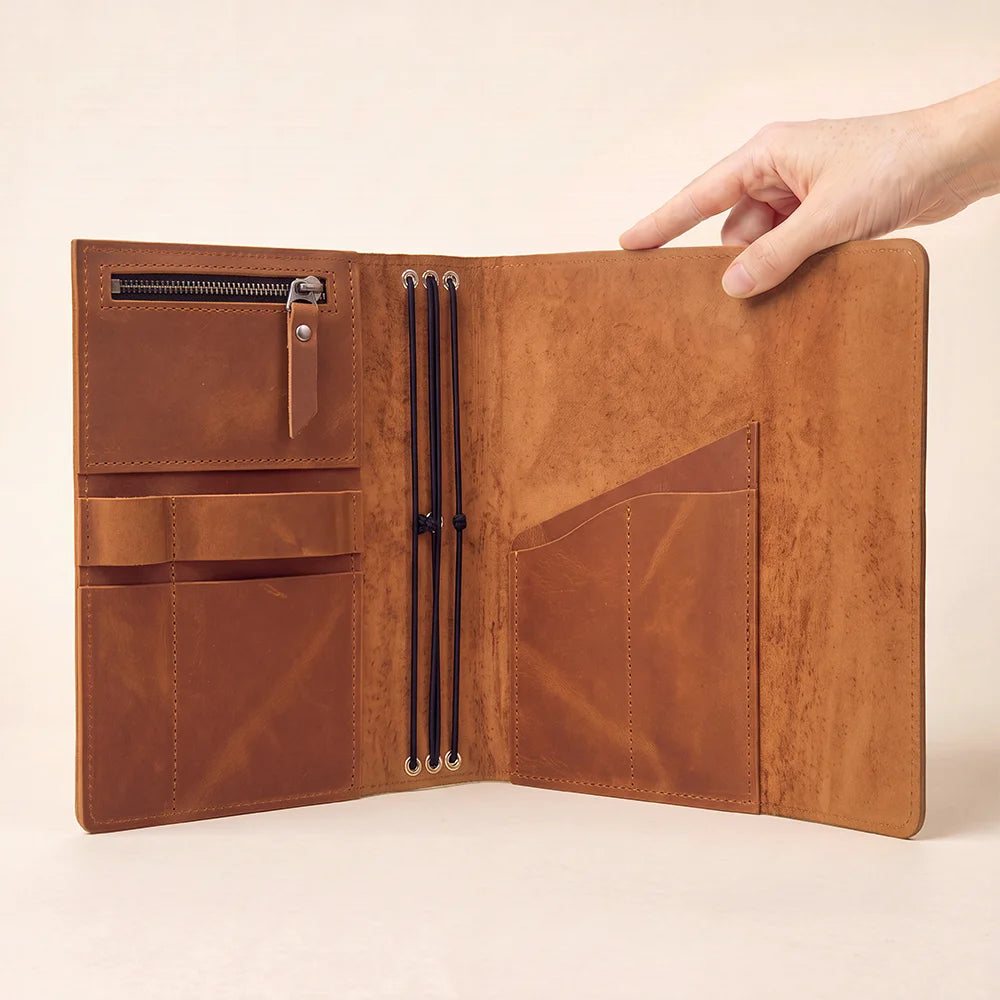 Natural leather planner case with organized interior storage and convenient access to writing instruments.