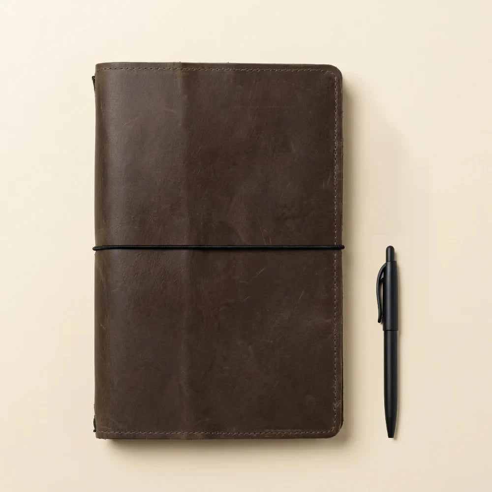 Genuine leather cover for journals featuring refillable elastics and functional travel organization.