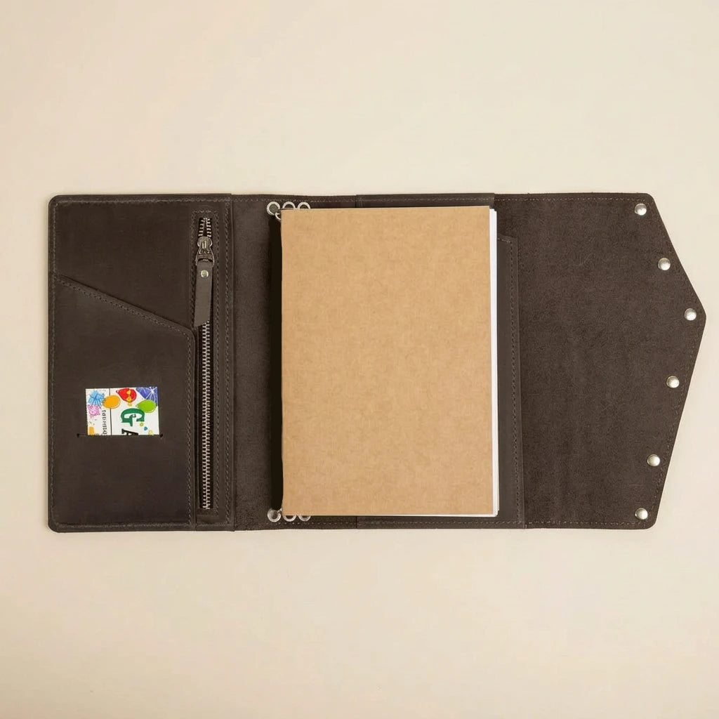 Brown leather journal with a card holder on a beige background