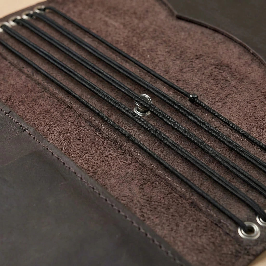 Close-up of a brown leather journal cover with black straps.