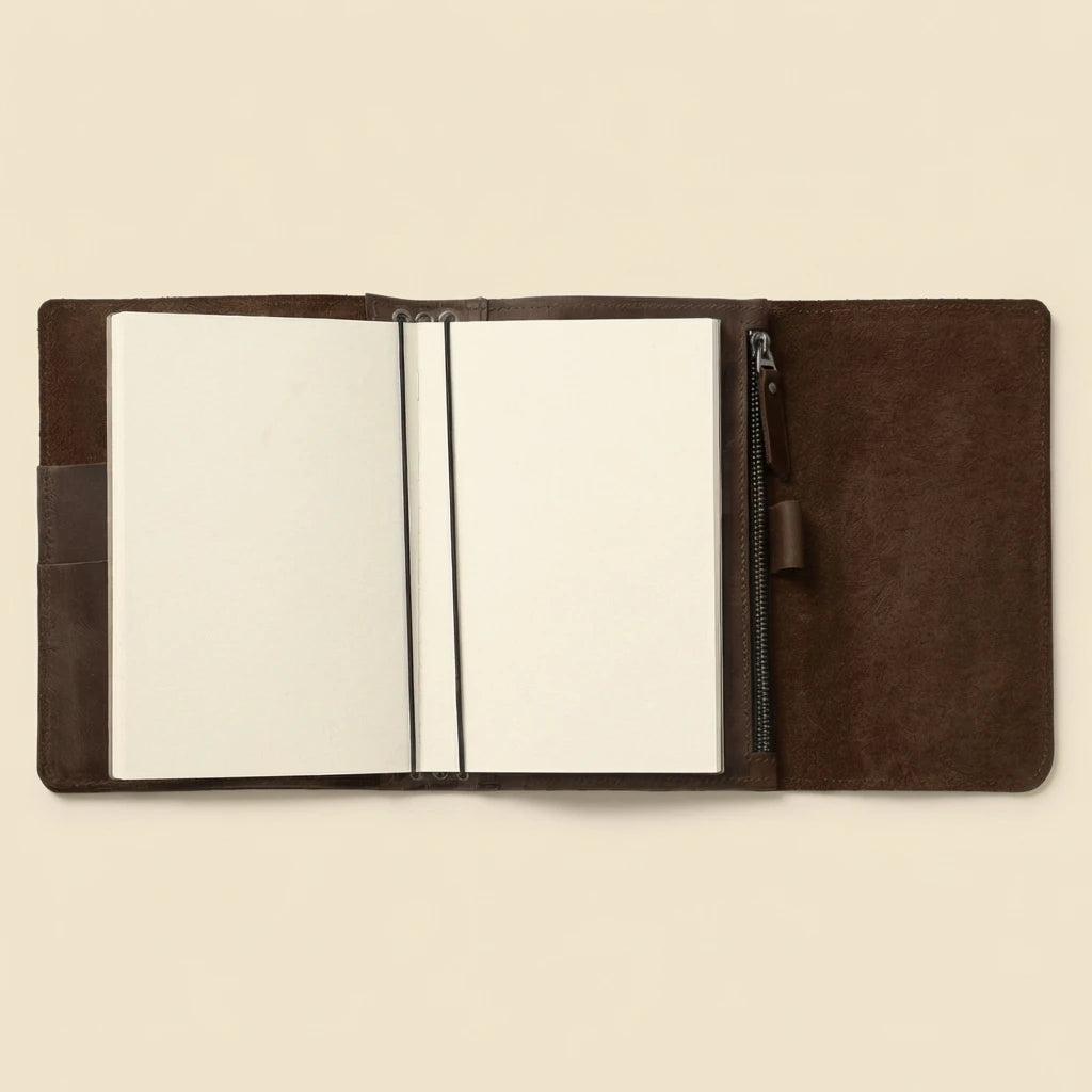 Brown leather notebook with a zipper on a beige background